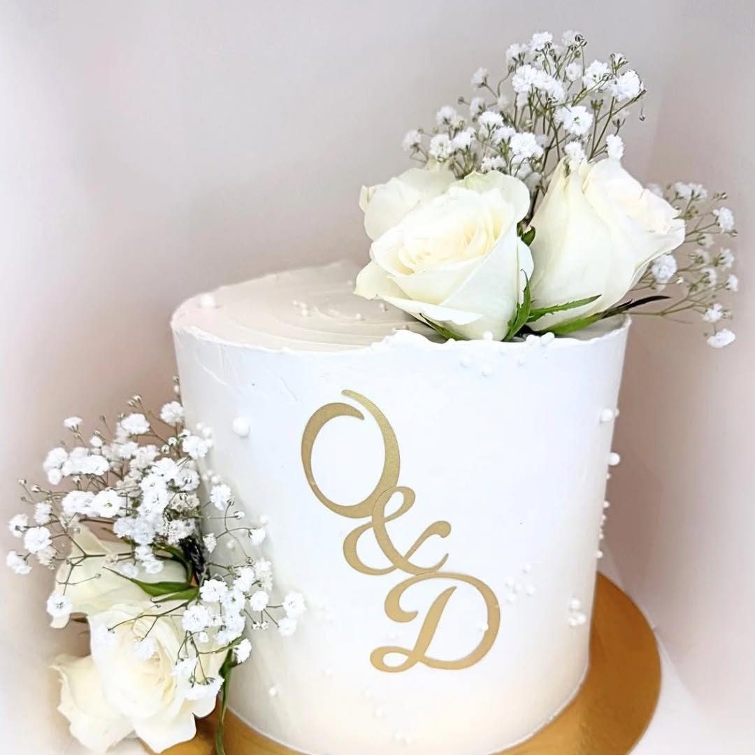 Gâteau de mariage blanc, roses blanches et initiales dorées